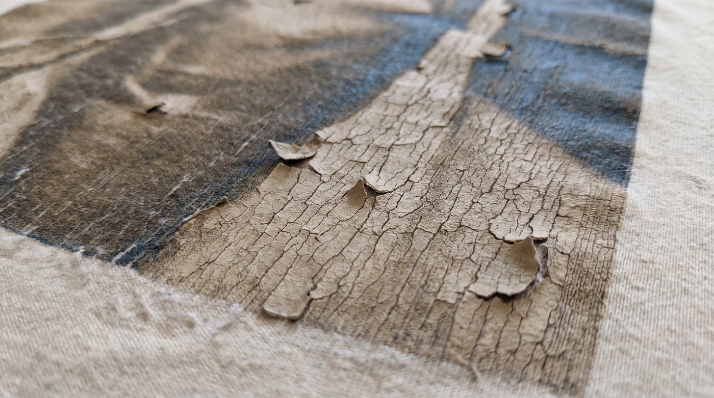 Close-up of a cracked and peeling heat transfer print after many washes